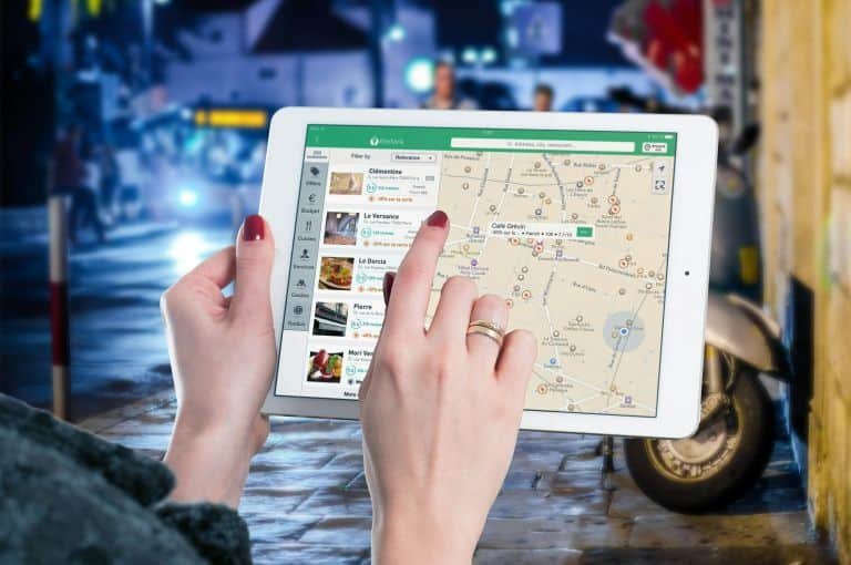 A woman using tablet with google maps opened in it
