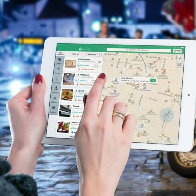 A woman using tablet with google maps opened in it
