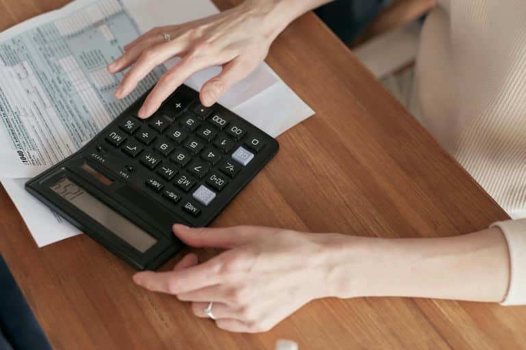 A woman calculating SEO cost on a calculator